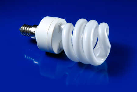 Ttwisted compact fluorescent lamp on blue backgroundの写真素材