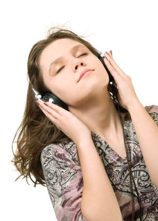 Teenage girl listening music on a white backgroundの写真素材