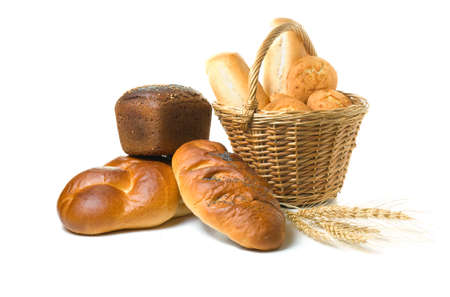 Various fresh baked goods with a basket, wheat grain and a cereal earsの写真素材