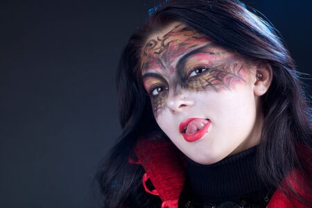 girl with a pattern on the face showing her tongue