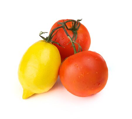Two tomatos and lemon on one branchの写真素材