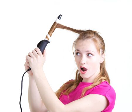 Girl in pink dress using curling isolated on whiteの写真素材