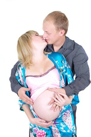 young pregnant woman kissing with husband isolated on white の写真素材