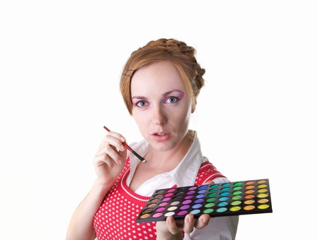 Young beautiful girl with cosmetics brush and color shadowsの写真素材