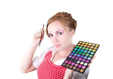 Young beautiful girl with cosmetics brush and color shadowsの写真素材