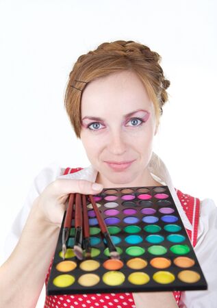 Young beautiful girl with cosmetics brush and color shadowsの写真素材