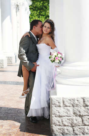 bride and groom kissing near columnの写真素材