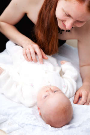 mom with her daughter laying on the bedの写真素材