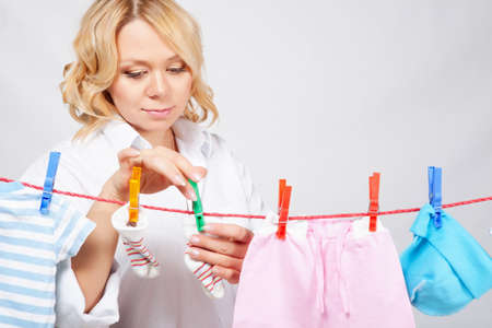 Woman hanging baby laundry to the ropeの写真素材