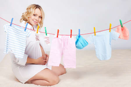 Woman hanging baby laundry to the ropeの写真素材