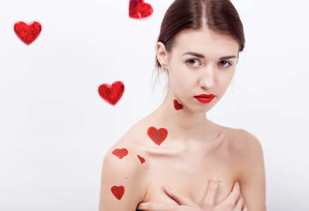 Brunette girl with red hearts isolated on whiteの写真素材