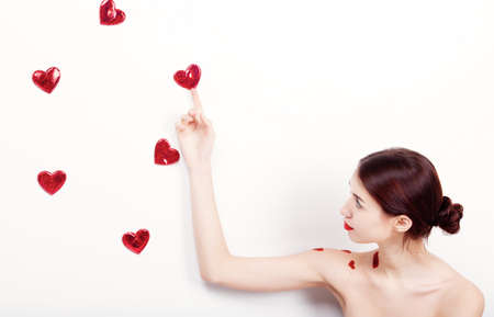 Brunette girl with red hearts isolated on whiteの写真素材