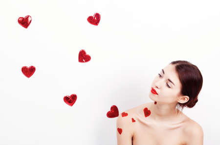 Brunette girl with red hearts isolated on whiteの写真素材