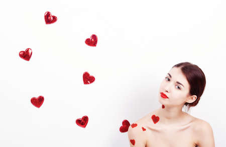 Brunette girl with red hearts isolated on whiteの写真素材