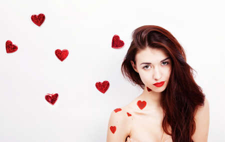 Brunette girl with red hearts isolated on whiteの写真素材