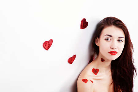 Brunette girl with red hearts isolated on whiteの写真素材