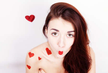 Brunette girl with red hearts isolated on whiteの写真素材