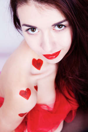 Brunette girl with red hearts isolated on whiteの写真素材
