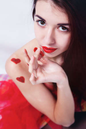 Brunette girl with red hearts isolated on whiteの写真素材