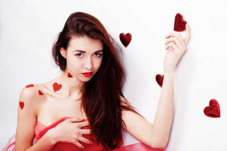 Brunette girl with red hearts isolated on whiteの写真素材