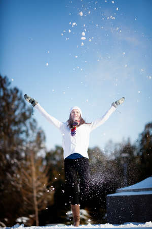 Girl playing with snow in parkの写真素材