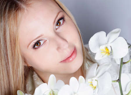 Girl with white orchid in studioの写真素材