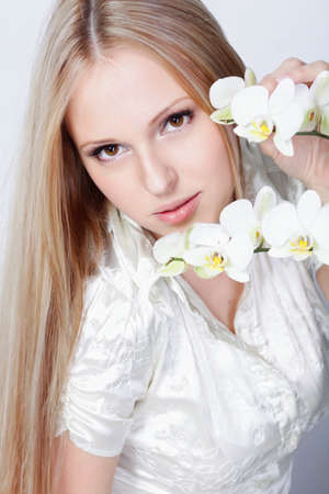 Girl with white orchid in studioの写真素材