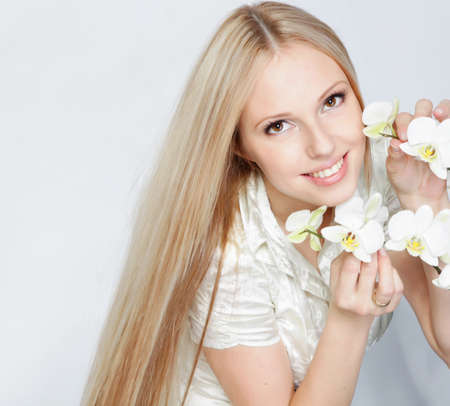 Girl with white orchid in studioの写真素材