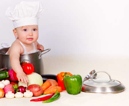 Baby cook with vegetables in studioの写真素材