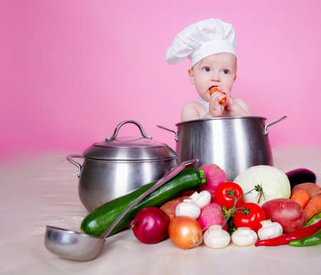 Baby cook with vegetables in studioの写真素材