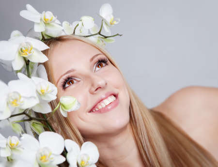 Beautiful blond girl with orchid flower in studioの写真素材
