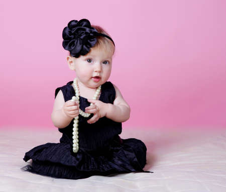 Little girl holding beads in handsの写真素材