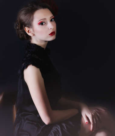 Beauriful smiling girl black dress sitting in studioの写真素材
