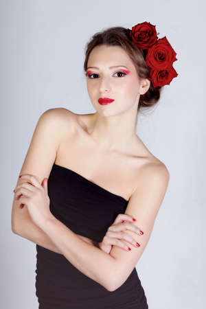Beauriful smiling girl with rose flowers in hairの写真素材