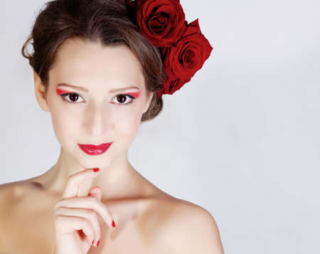 Beauriful smiling girl with rose flowers in hairの写真素材