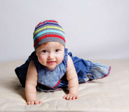 Little girl laying on the bed in studioの写真素材