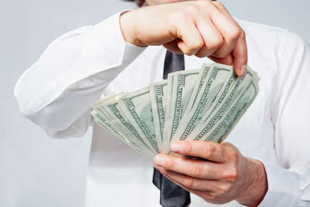 A man s hand holding a handful of dollarsの写真素材