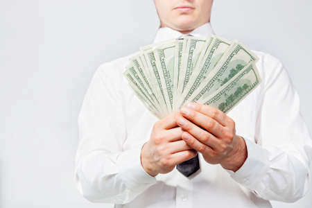 A man s hand holding a handful of dollarsの写真素材