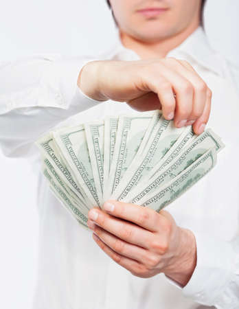 A man counting a handful of dollars.の写真素材