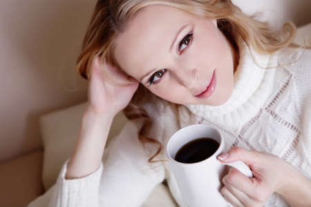 Beauriful girl drinking coffee at homeの写真素材