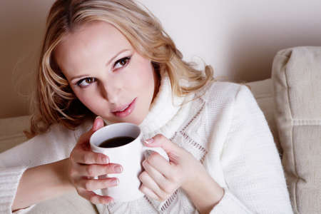 Beauriful girl drinking coffee at homeの写真素材