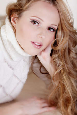 Beauriful girl in white sweater at homeの写真素材