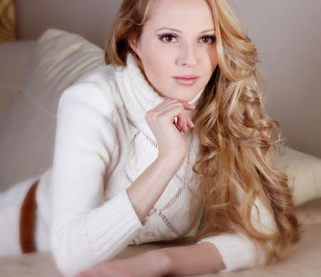 Beauriful girl in white sweater at homeの写真素材