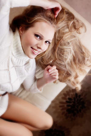 Beauriful girl in white sweater at homeの写真素材