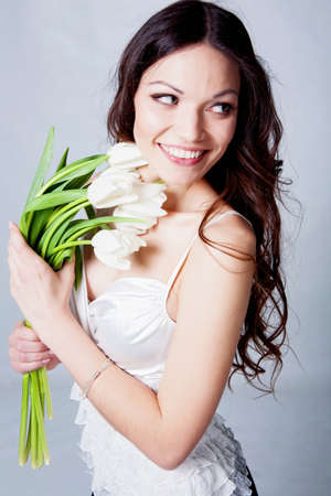 Beauriful brunette girl with tulip flowers in studioの写真素材