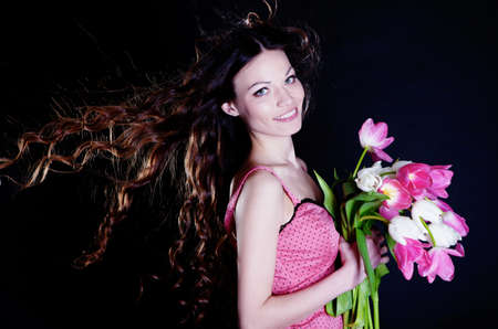 Low key image of young woman with tulipの写真素材