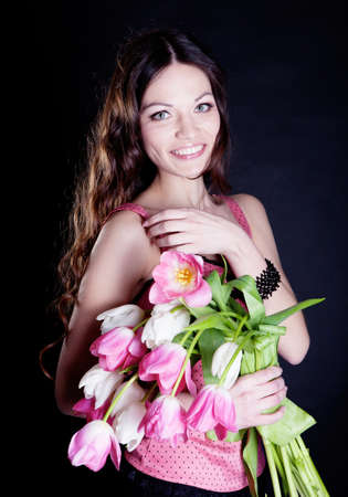 Low key image of young woman with tulipの写真素材