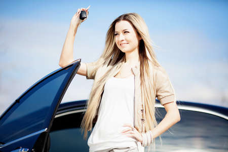 Beautiful girl with car key in handの写真素材