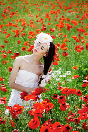Beautiful girl in poppies meadowの写真素材