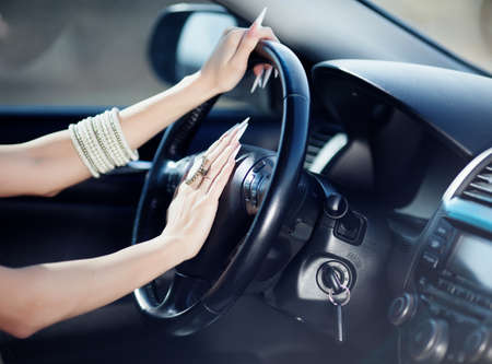 Beautiful girl hands on the drivewheel of carの写真素材